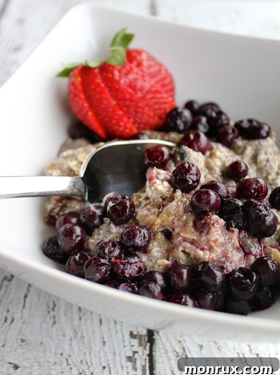 A beautifully presented bowl of Nutritarian Chia Breakfast Pudding, garnished with fresh blueberries and a single strawberry, ready to be enjoyed.
