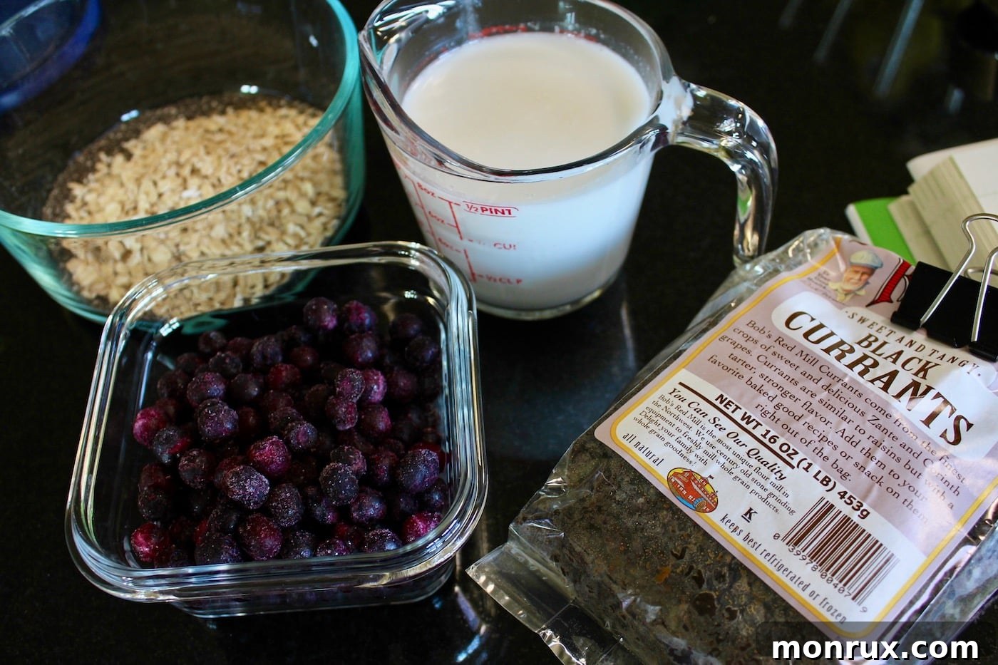 Close-up of key ingredients for nutritarian chia pudding, including oats, chia seeds, blueberries, and vanilla bean, showcasing their natural goodness.