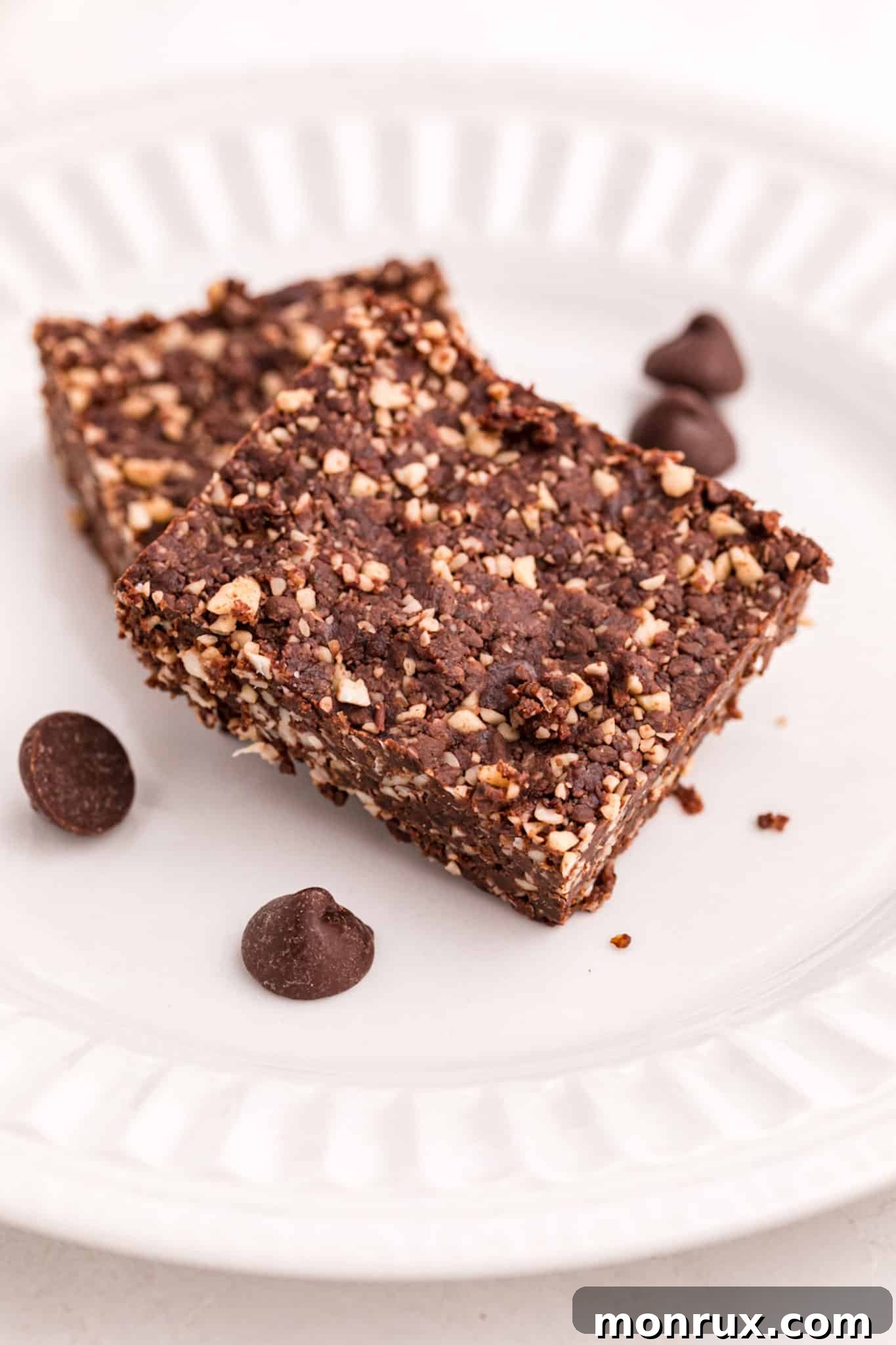 A single serving of vegan no-bake brownie on a white plate, garnished subtly.