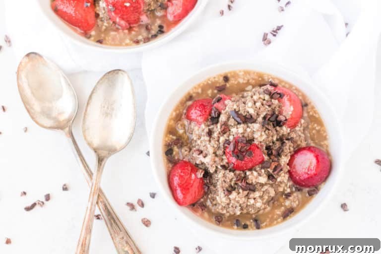 A beautifully presented bowl of cauliflower oatmeal garnished with fresh strawberries and cacao nibs.