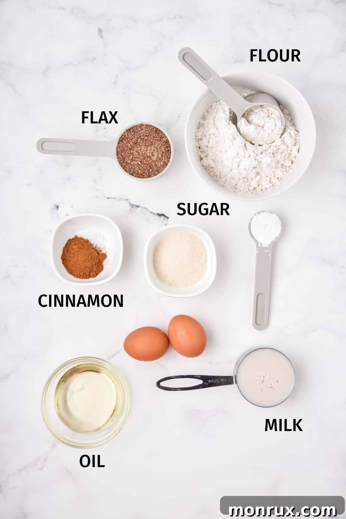 Various ingredients for flax muffins displayed in small white bowls on a pristine white surface, highlighting freshness and quality.