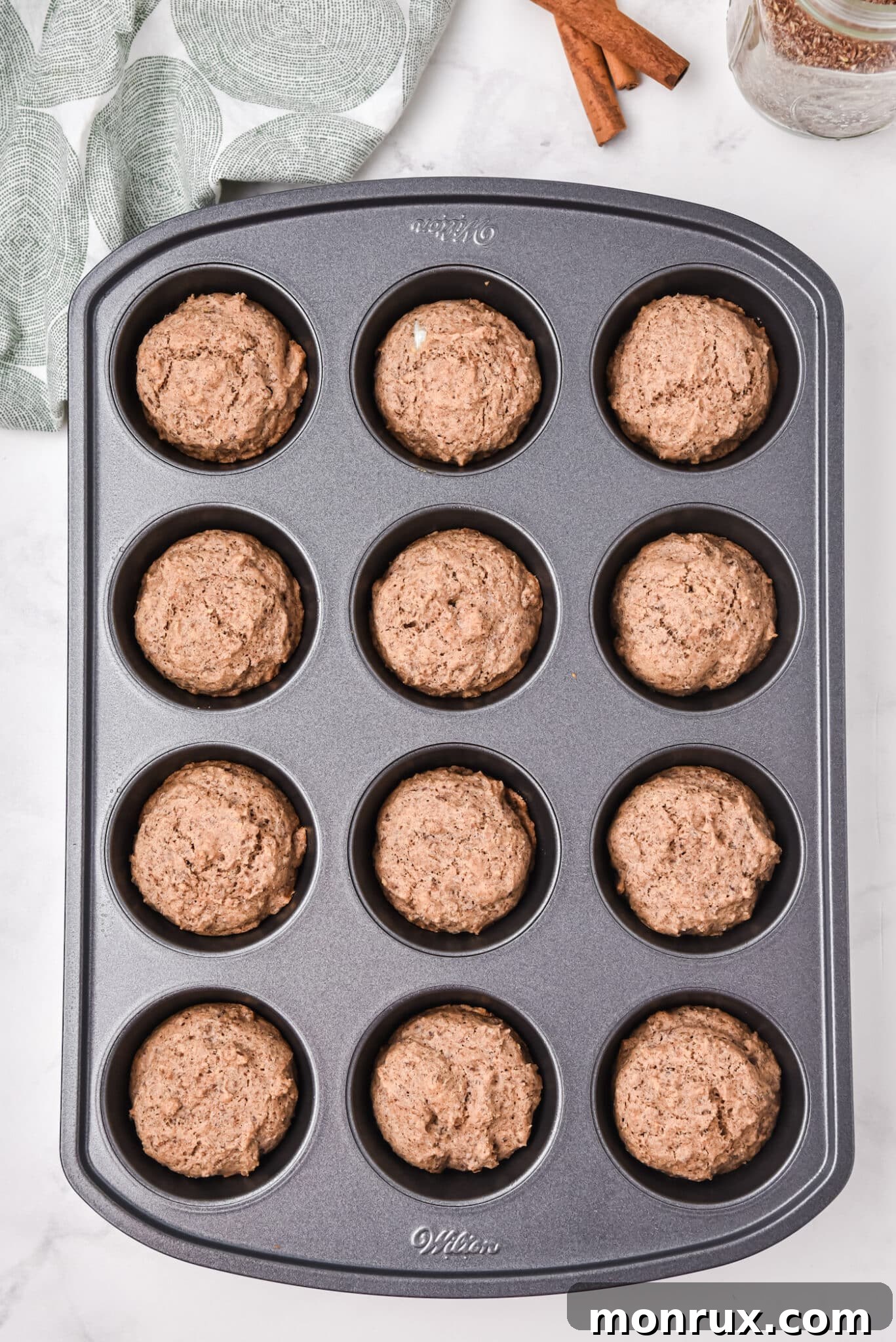 A muffin tray brimming with freshly baked, golden-brown flax muffins, inviting and perfectly risen.