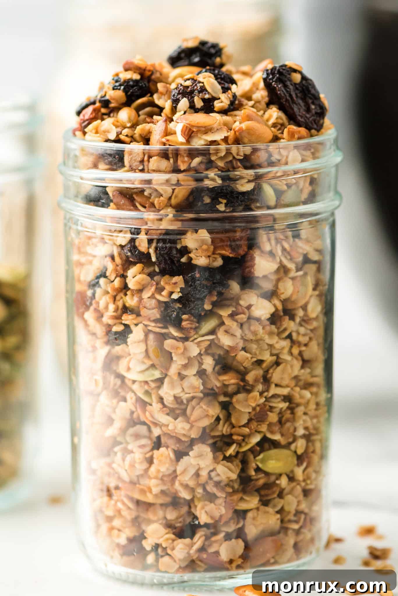 A rustic glass jar filled with freshly made air fryer granola, showcasing the golden clusters, ready for storage or serving.