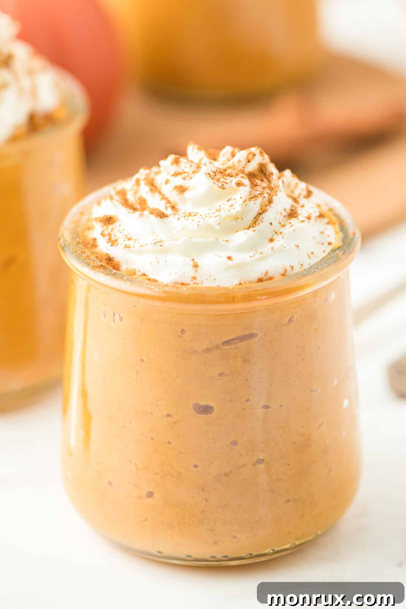 A beautifully presented dairy-free healthy pumpkin pudding, topped with fluffy coconut whipped cream, ready to be enjoyed.