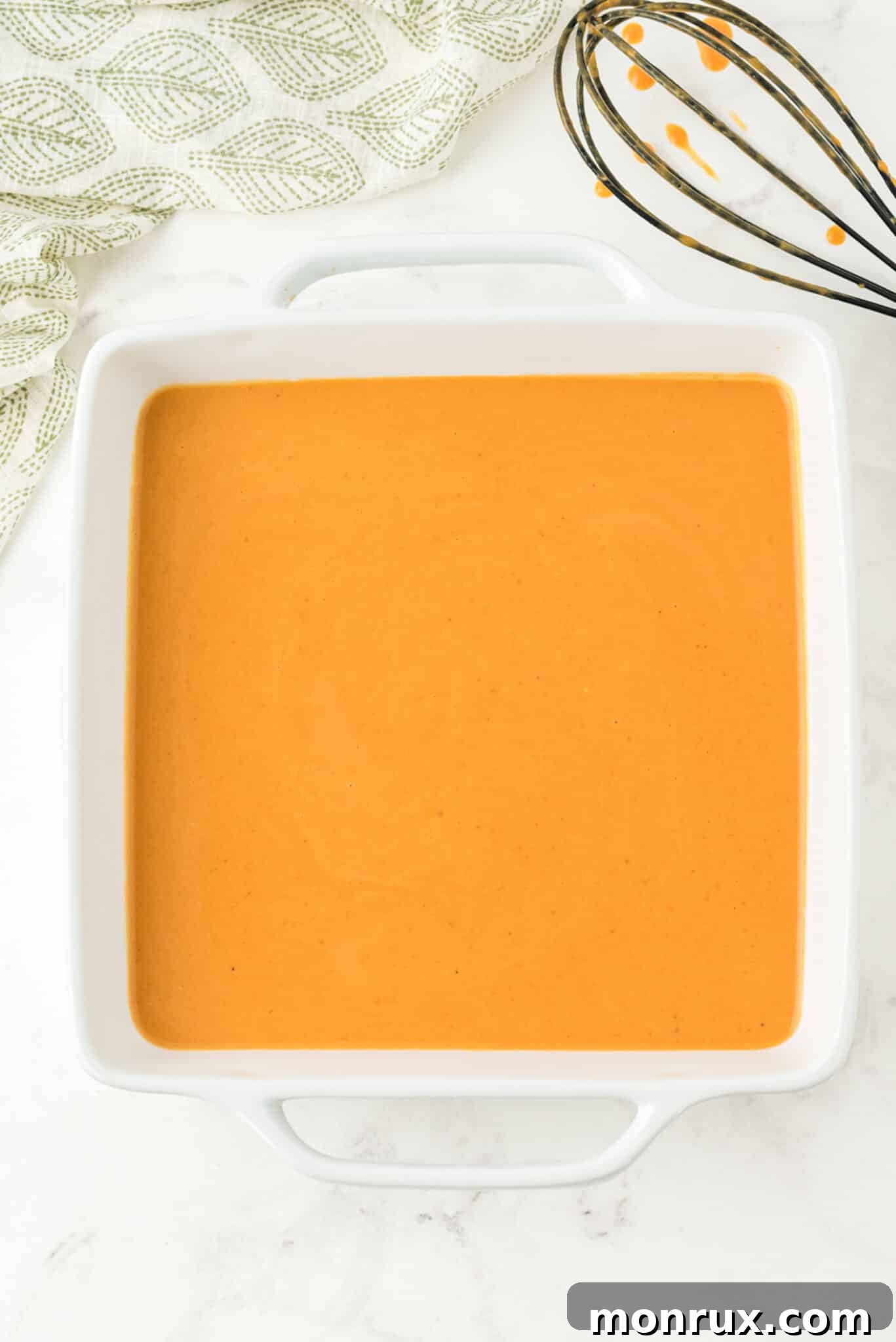 The dairy-free pumpkin pudding mixture poured into a baking dish, ready for the oven.