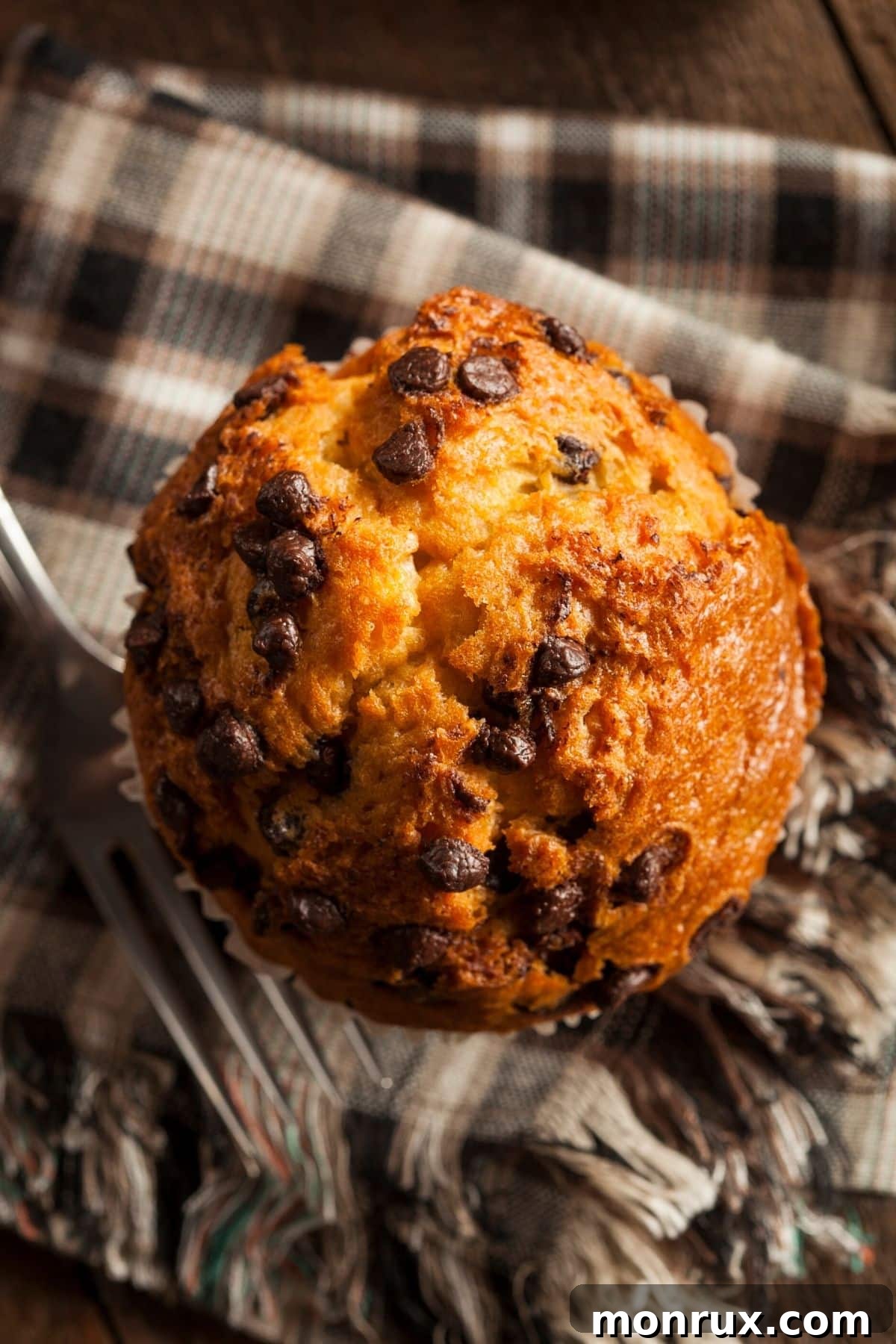 A perfectly baked cassava flour muffin placed delicately on a linen cloth, with a fork beside it, inviting a taste.