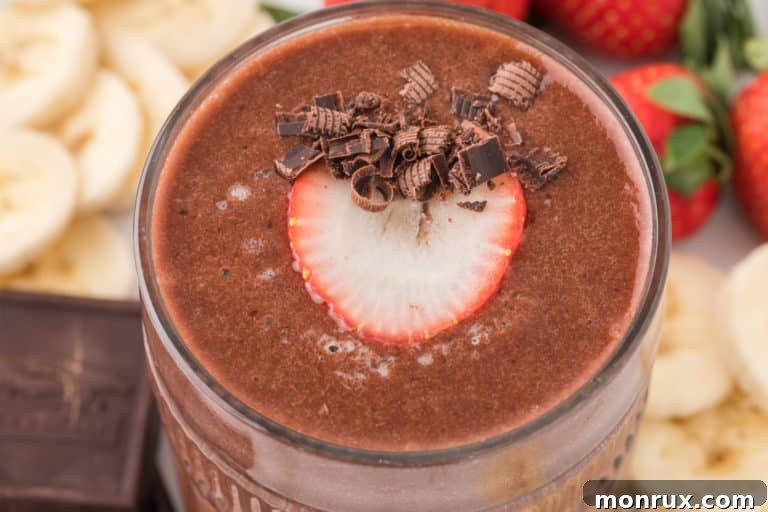 strawberry banana chocolate smoothie in glass.