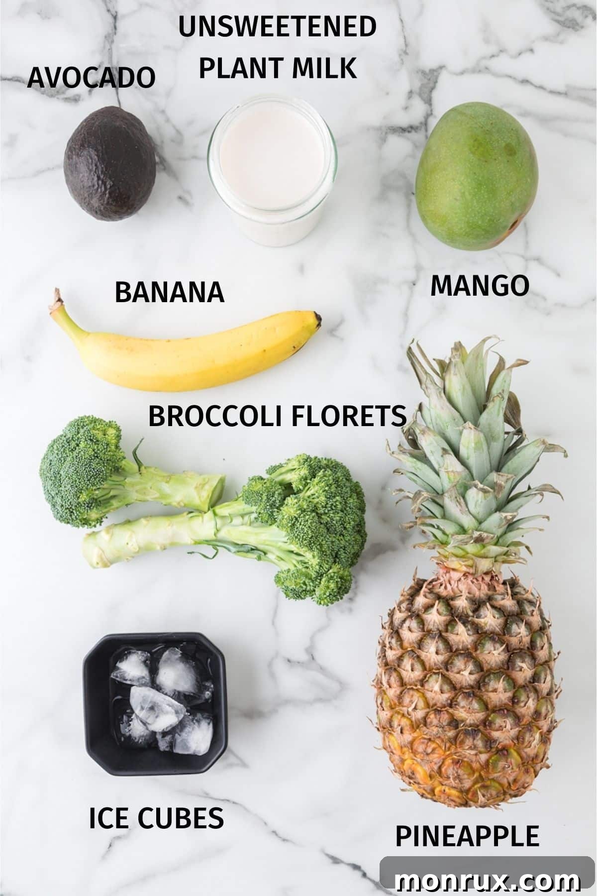 Various fresh and frozen ingredients for a broccoli pineapple smoothie, including plant milk, broccoli florets, pineapple, mango, banana, and avocado.