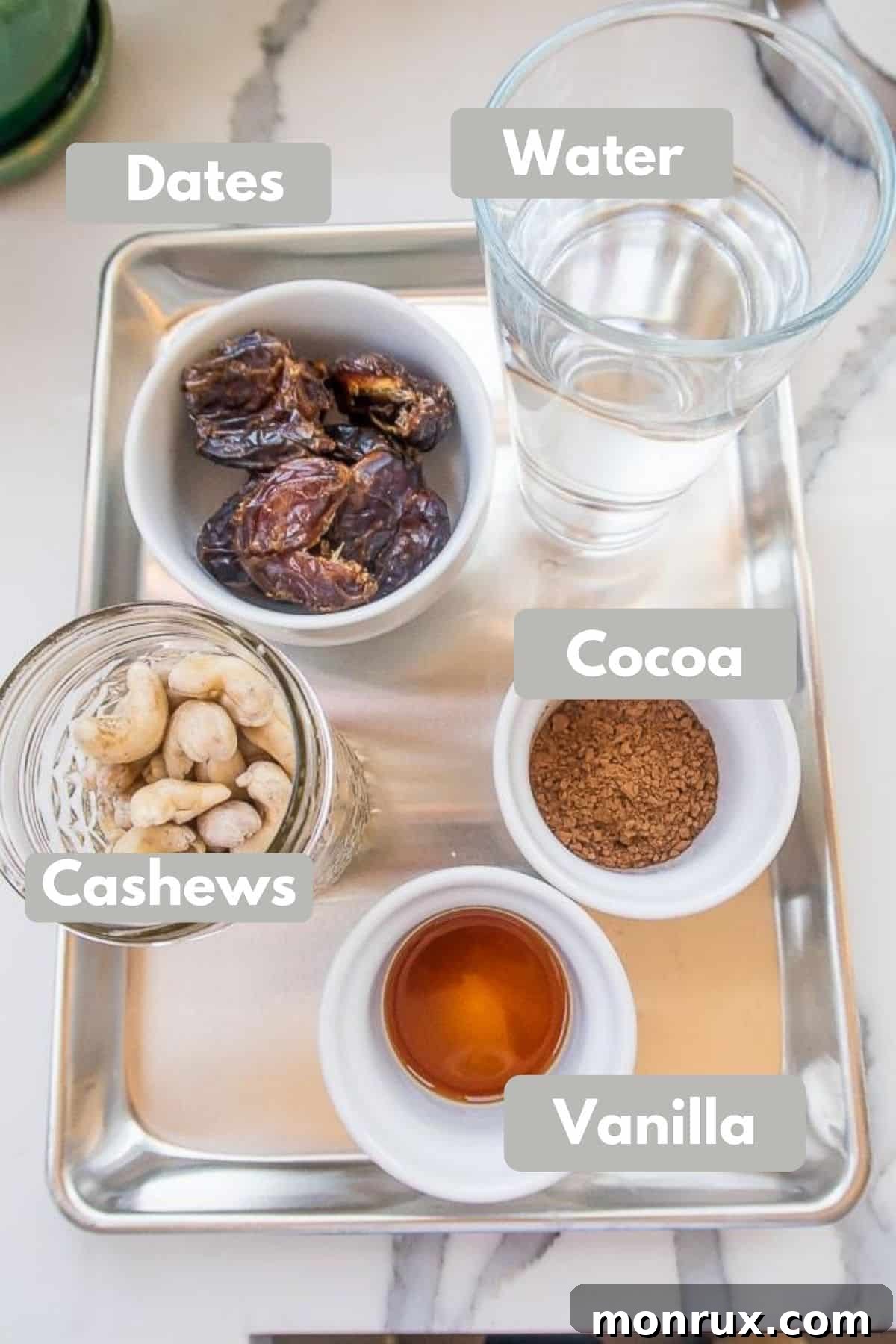 Labeled photo showcasing the four key ingredients for vegan fudgesicles: cashews, dates, cocoa powder, and vanilla extract.