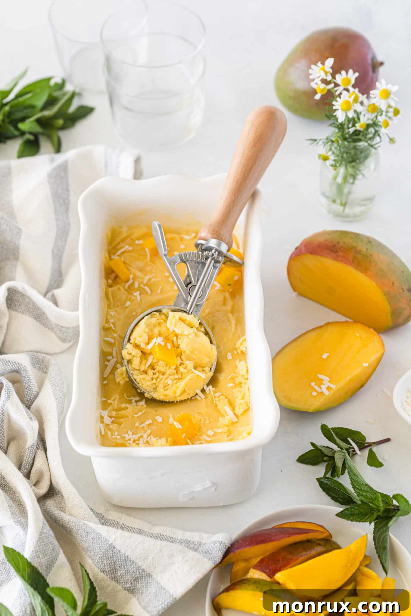 Creamy vegan mango ice cream frozen in a loaf pan, ready for scooping and serving.