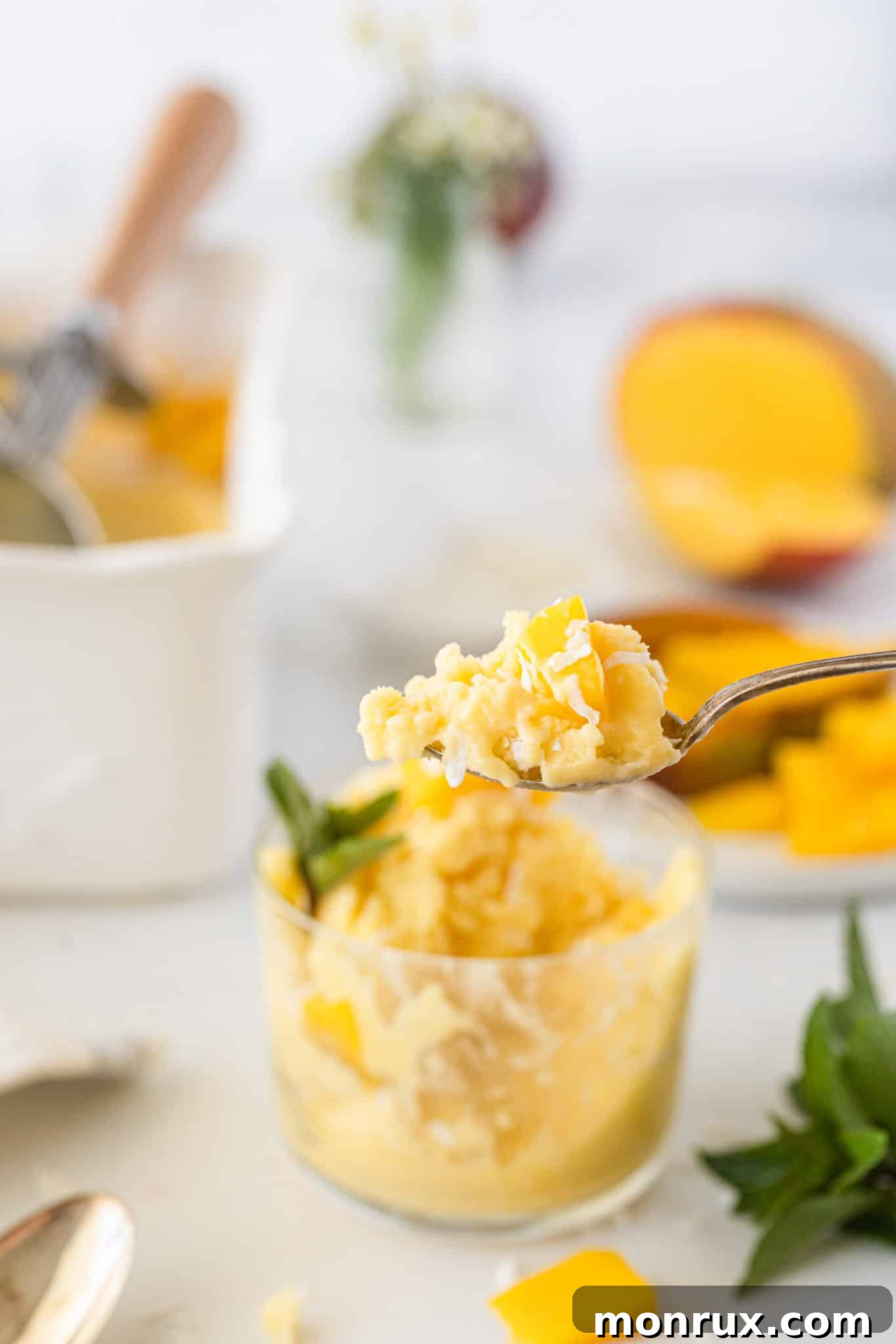 Close-up shot of a spoonful of vegan mango ice cream, showing its smooth and creamy texture.