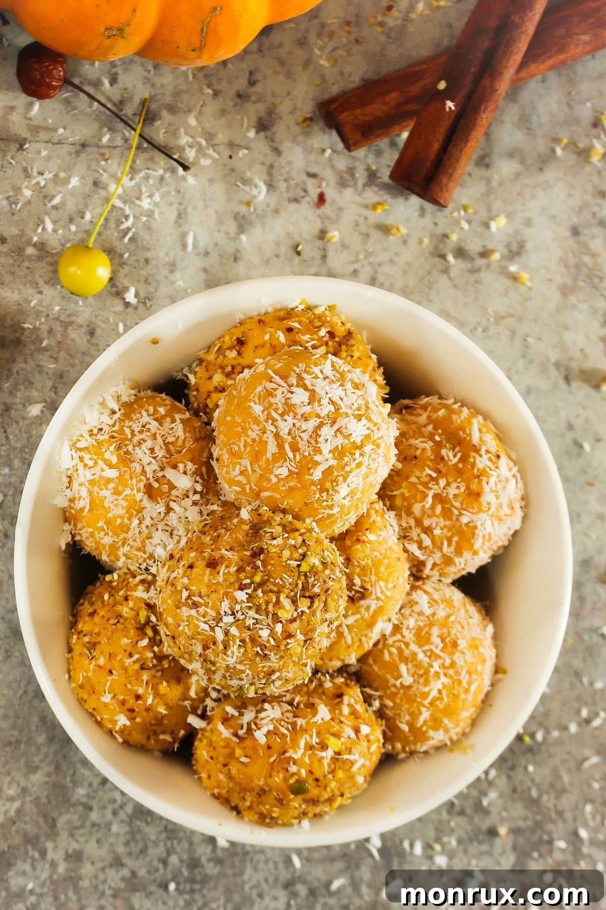 Bowl of pumpkin protein balls rolled in shredded coconut, ready to eat and enjoy as a healthy snack or dessert.