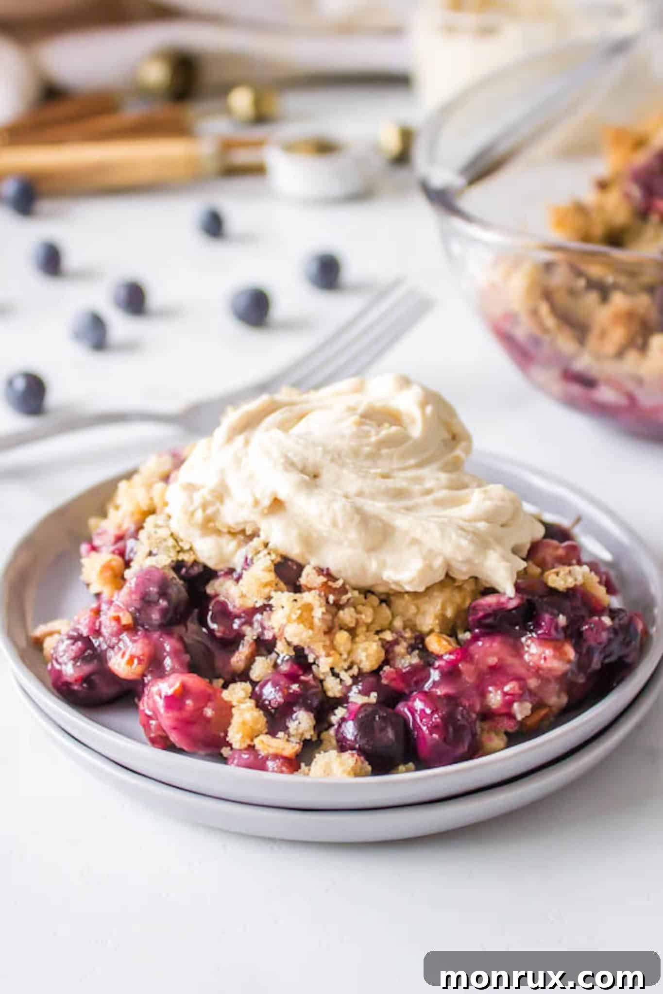 blueberry crisp served with a coconut whip topping.