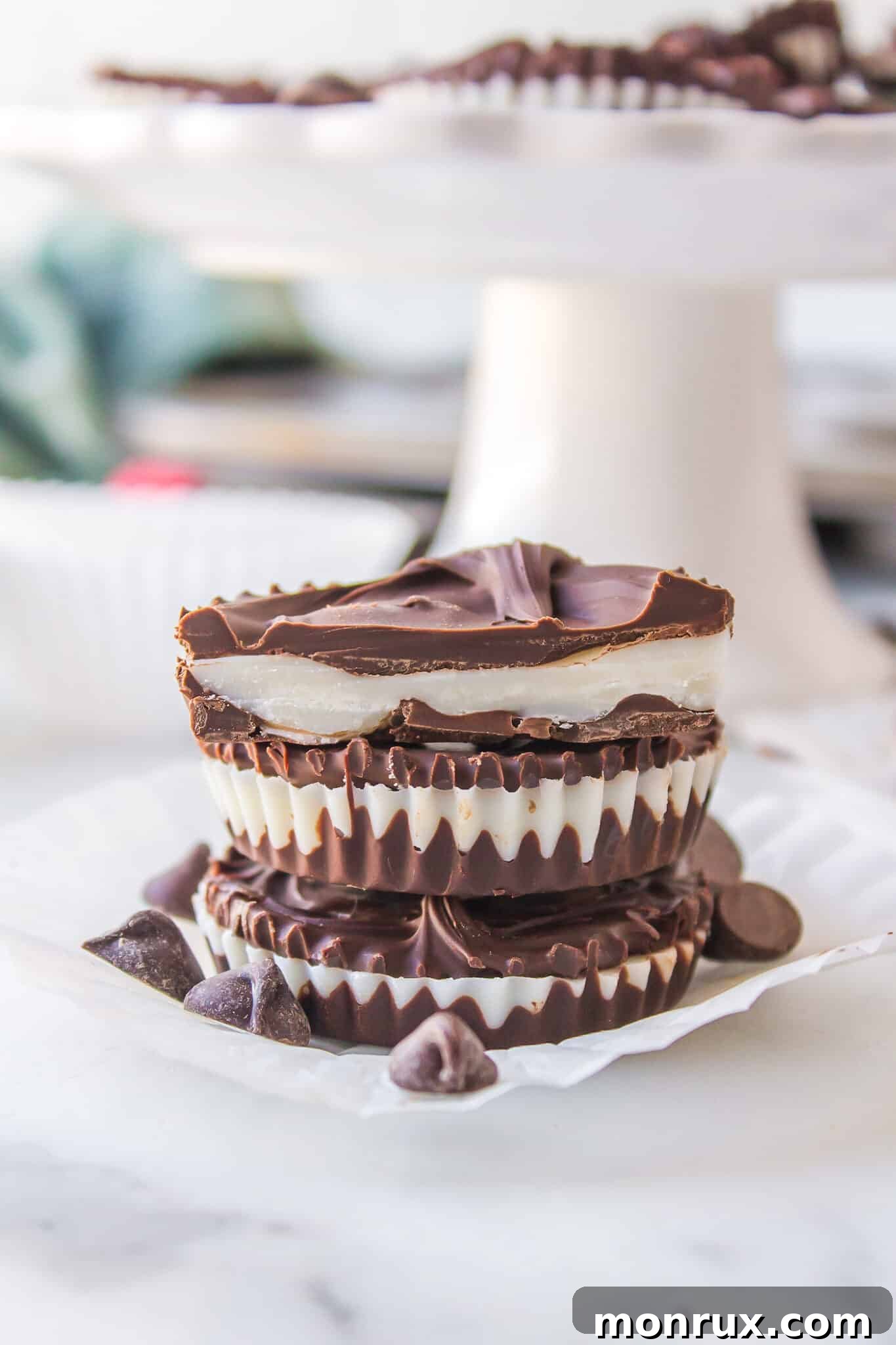 Three homemade peppermint patties stacked on a white plate, ready to be enjoyed.