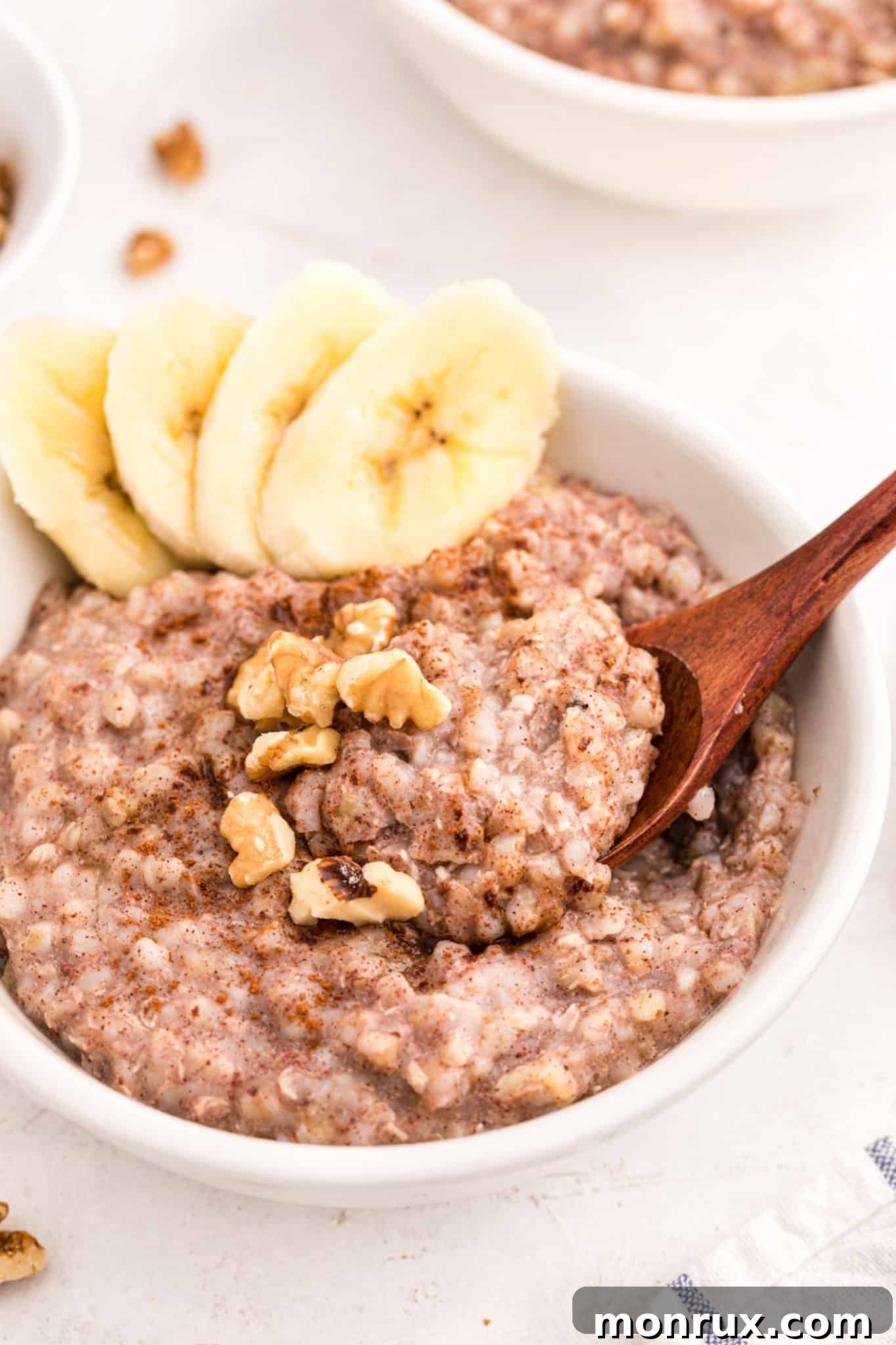 buckwheat porridge in a bowl with sliced bananas and walnuts, ready to eat.