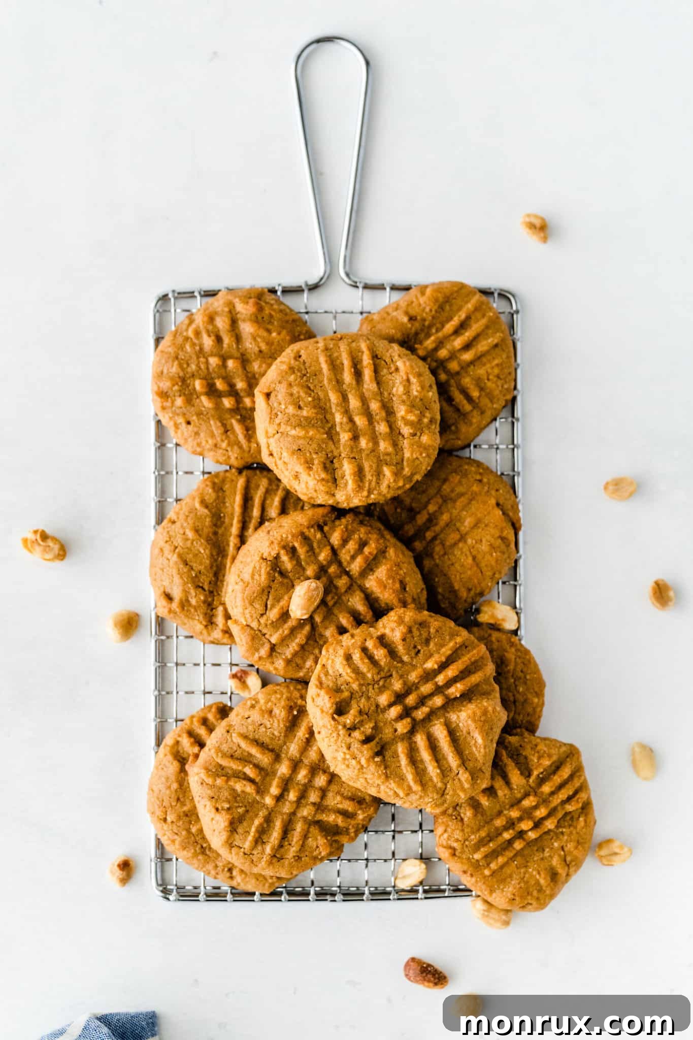 Freshly baked almond flour peanut butter cookies cooling on a wire rack.