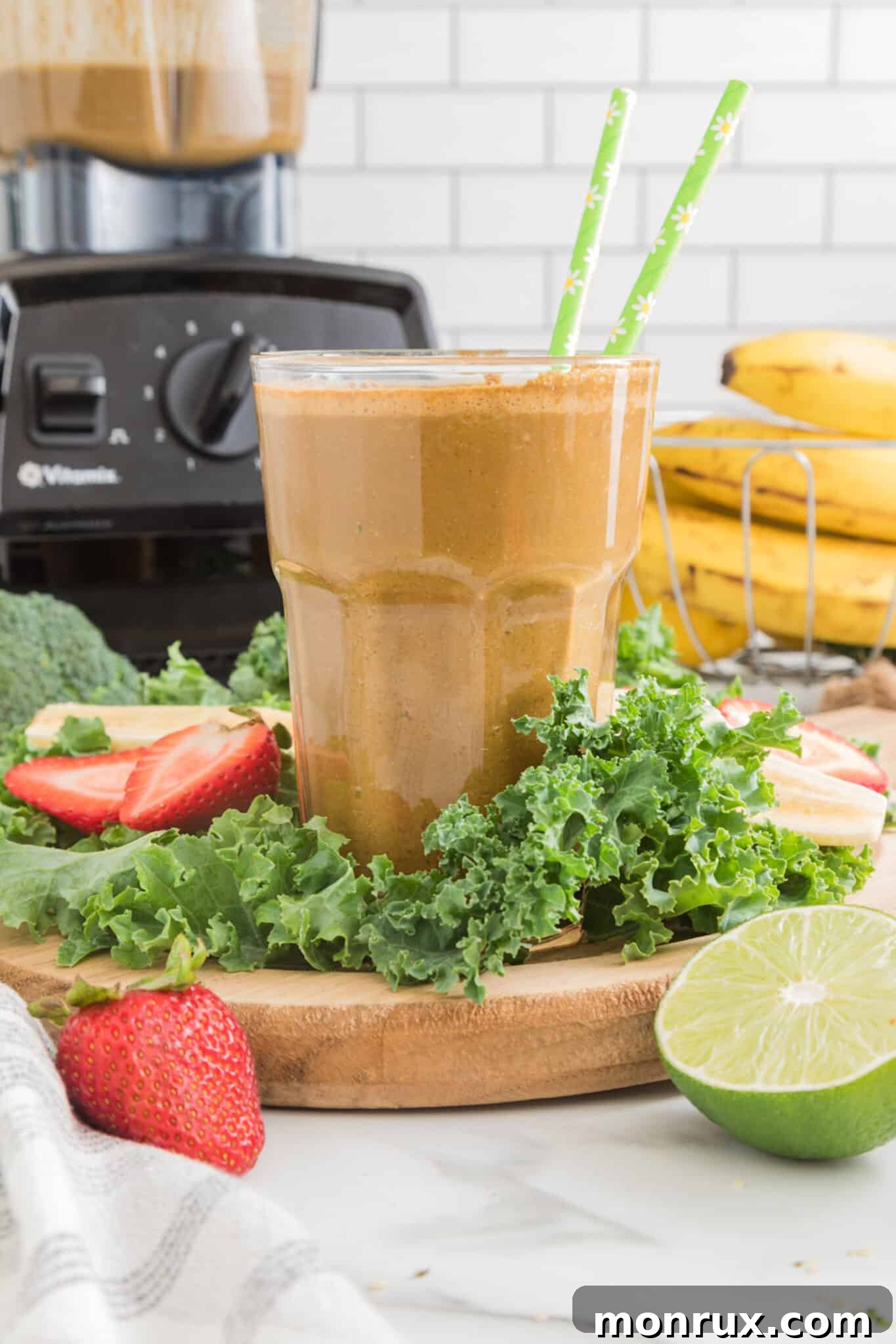An inviting image of the cancer-fighting cocoa green smoothie, perfectly presented in a glass with two green straws.
