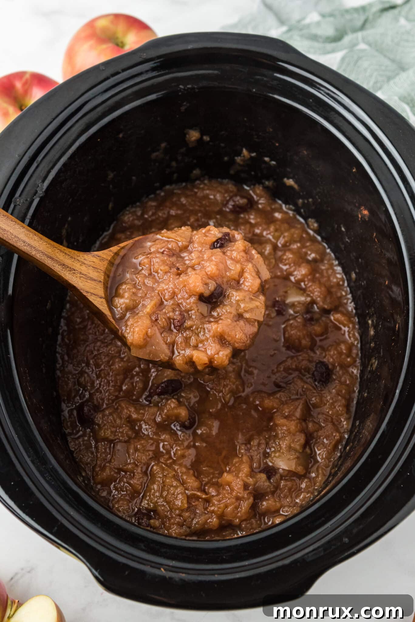Cooked applesauce in the slow cooker, ready to be served, with steam gently rising.