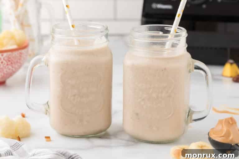 Peanut butter cauliflower smoothie with straws, poured into glasses and garnished.