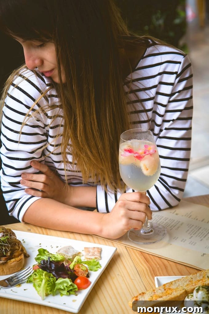 woman eating lunch with a fruit infused water. 