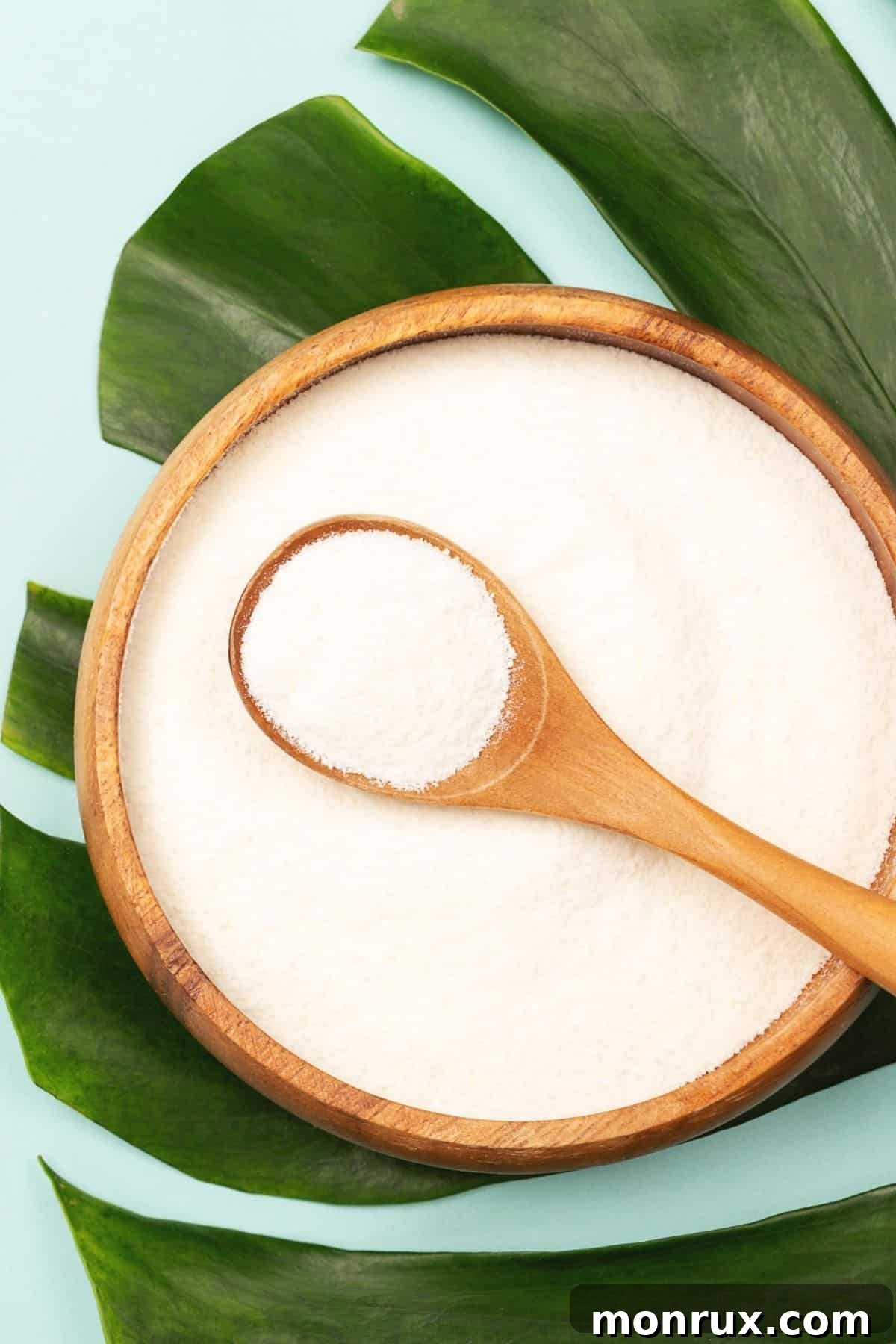 bowl of powdered collagen protein on top of a palm leaf, symbolizing natural health.