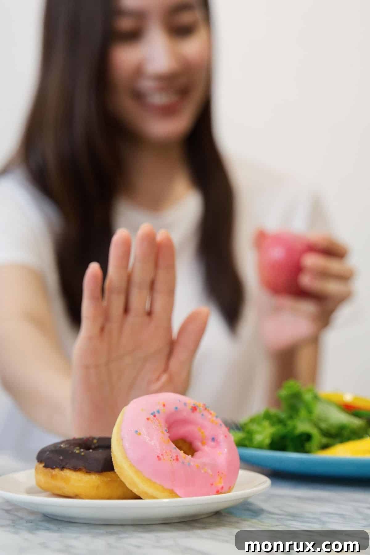 A woman kindly refusing a donut in favor of healthier food options, symbolizing a commitment to a sugar-free lifestyle.
