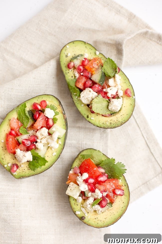 Delicious stuffed avocados topped with fresh tomatoes and cheese, a perfect example of a healthy fat-rich meal.