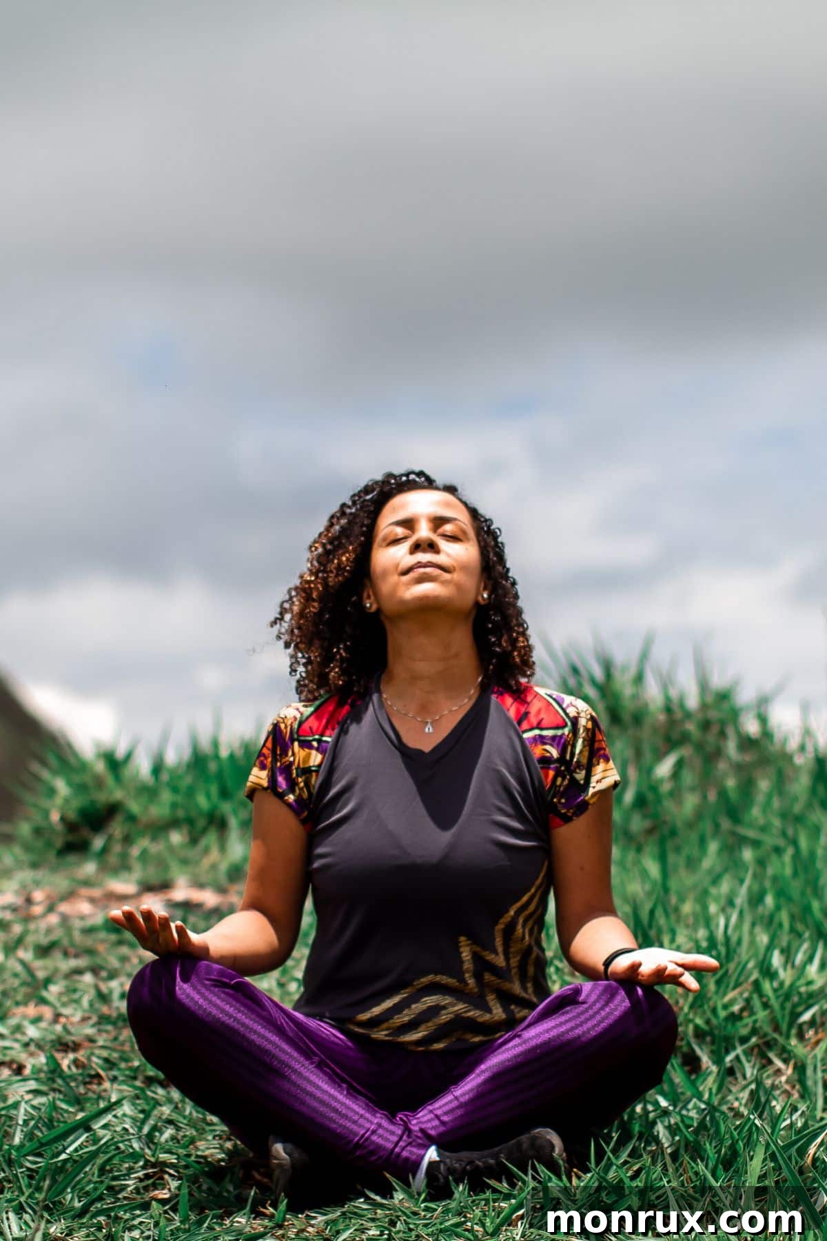 A young woman meditating peacefully outdoors, symbolizing calm and stress management.