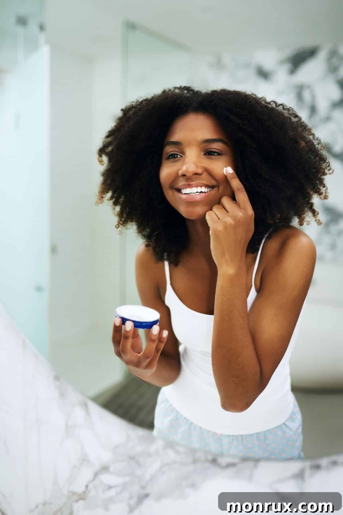 A young woman applying a soothing cream to her face, a common practice for managing skin issues.