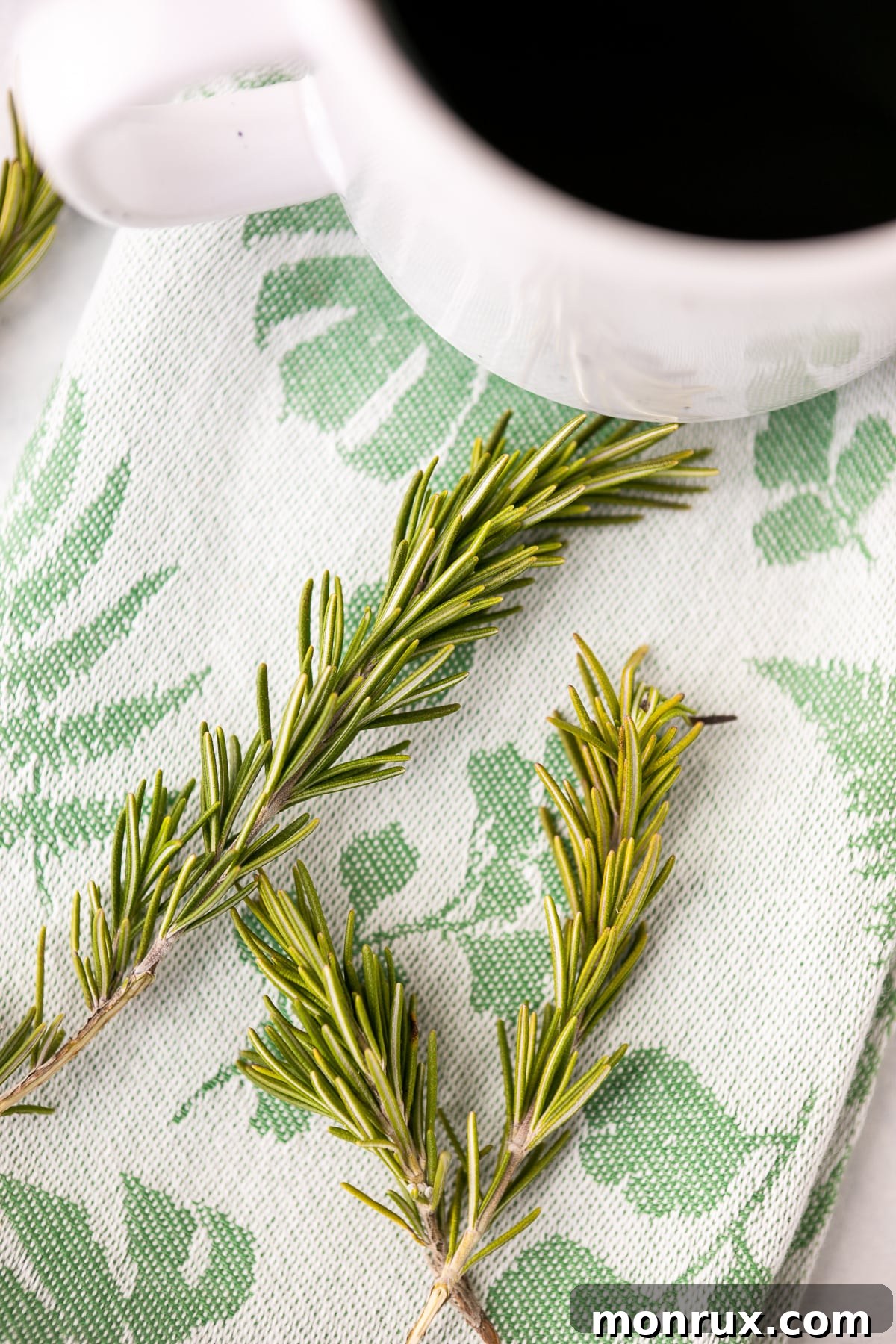 Close-up shot of vibrant green fresh rosemary sprigs, highlighting their textured leaves and natural beauty.
