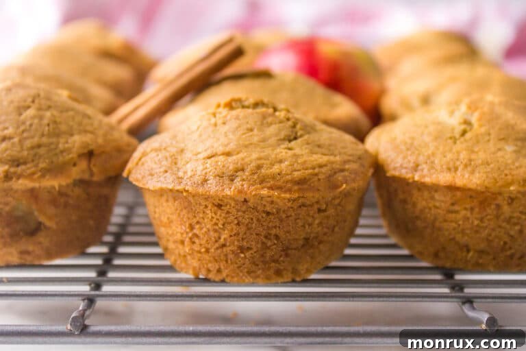 Gluten free apple muffins resting on a wire rack, cooling after baking.