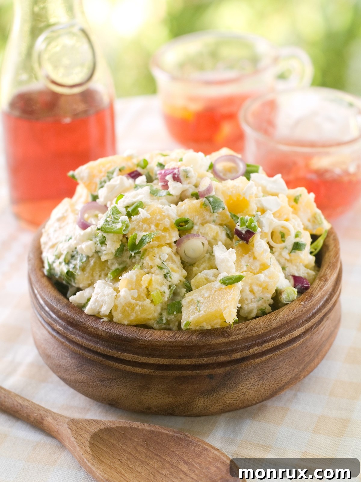 egg salad without eggs in wooden bowl on table with pink drink.