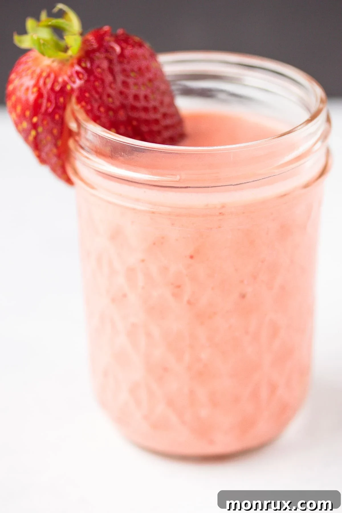 Creamy strawberry dressing stored in a glass jar, showcasing its smooth texture.
