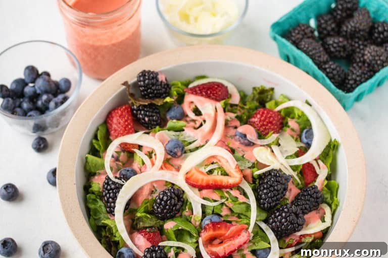Close-up of creamy strawberry dressing on top of a fresh green salad.