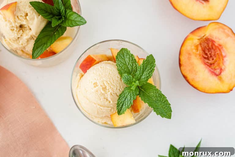 Scoops of creamy peach ice cream in a white container