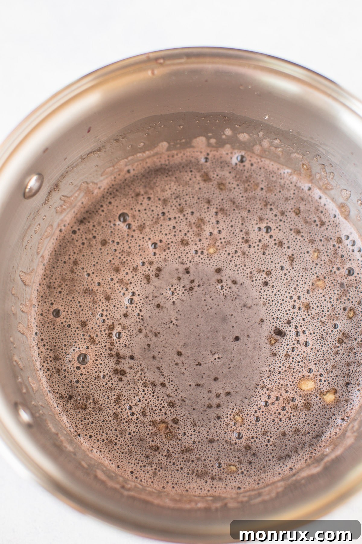 ingredients for gummies in a saucepan, showing fruit juice warming up.