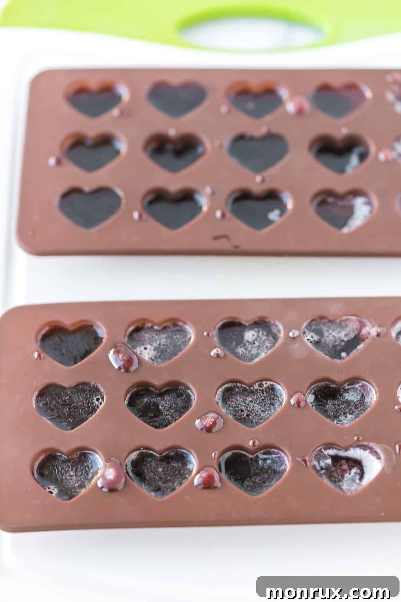 cbd gummy mixture poured into heart-shaped molds, ready for chilling.