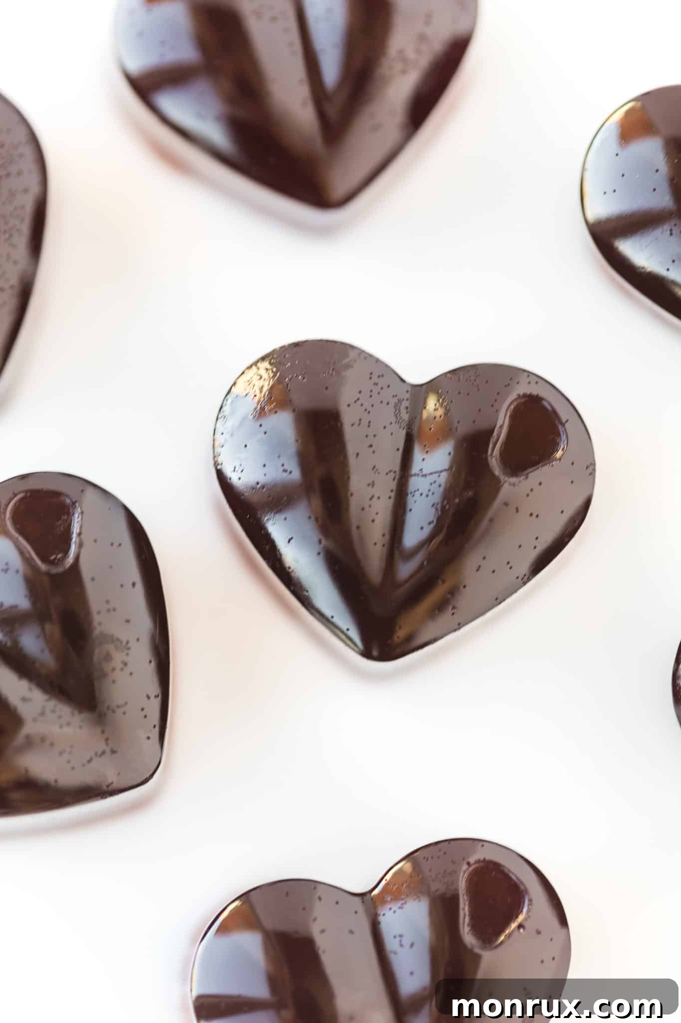 close-up of a single heart shaped pink gummy on a table, highlighting its texture.