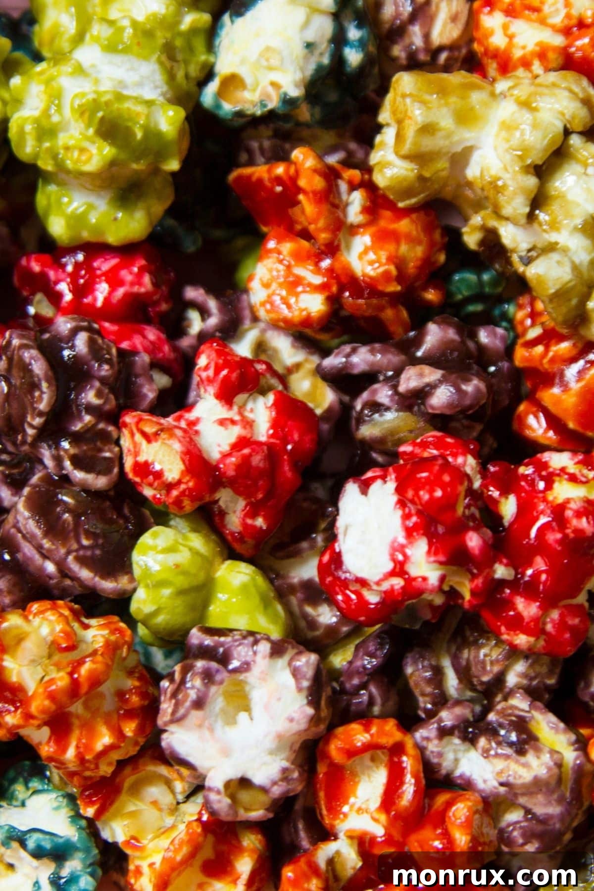 Popcorn kernels popped and dyed in vibrant, natural colors, ready for a festive Halloween spread.