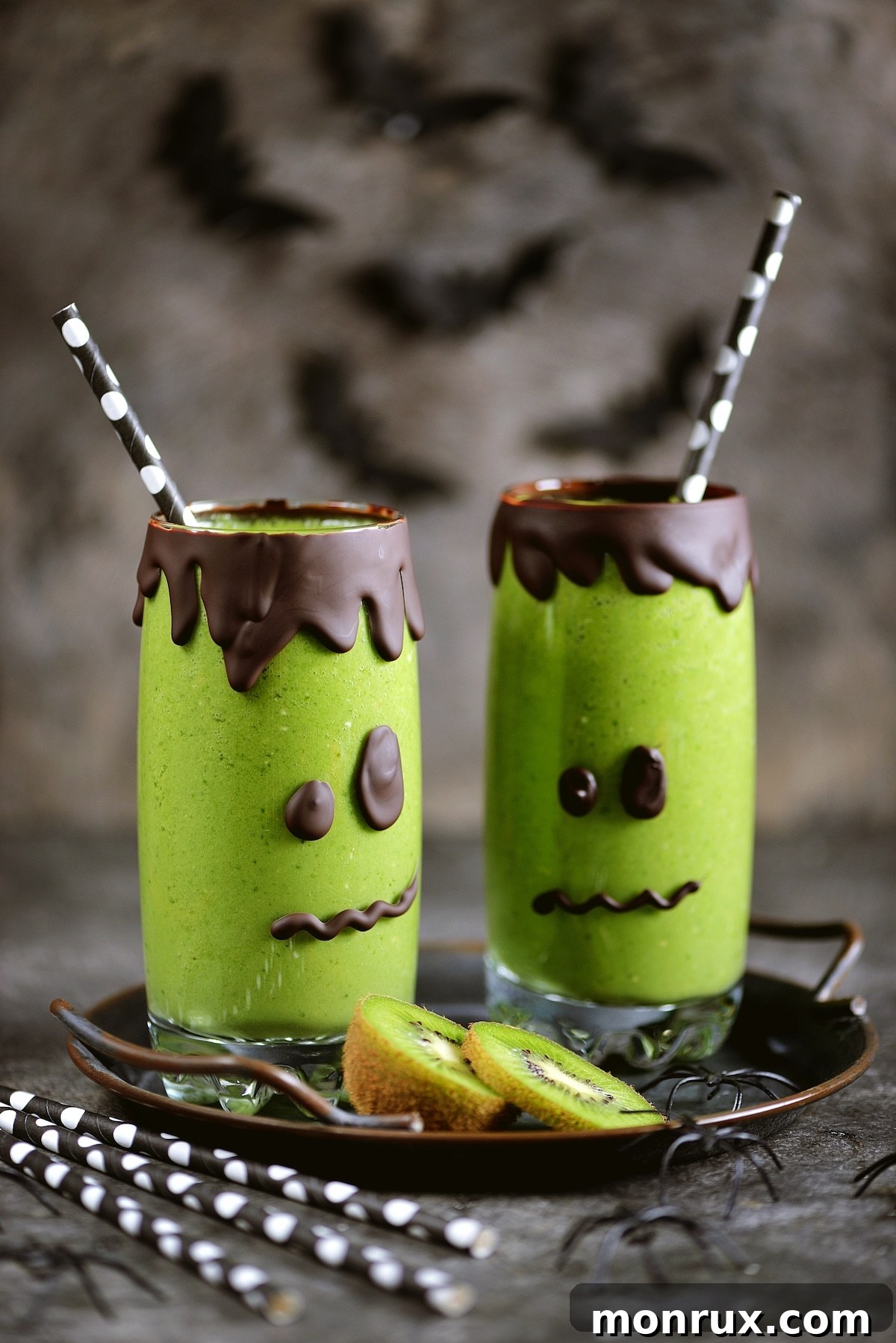 A vibrant green smoothie served in Frankenstein-themed glasses, perfect for Halloween.