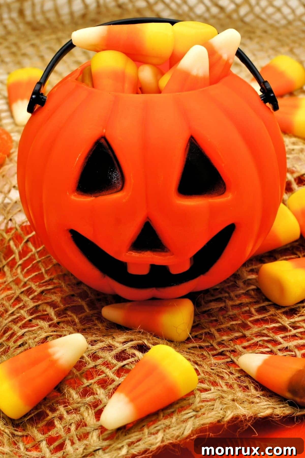 A festive jack-o'-lantern bowl brimming with colorful candy corn, ready for Halloween trick-or-treaters.