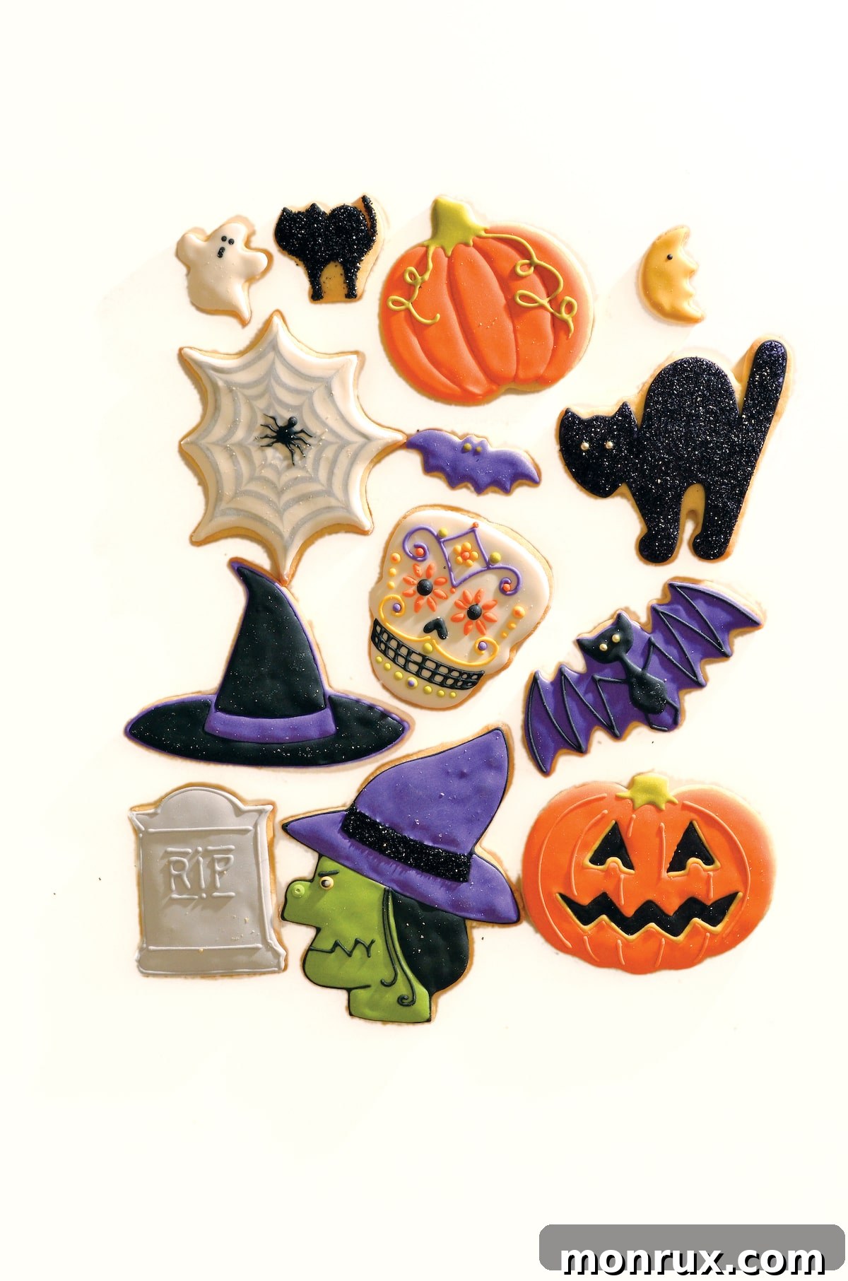 An assortment of wonderfully decorated Halloween cookies, featuring ghosts, pumpkins, and bats, arranged on a table.