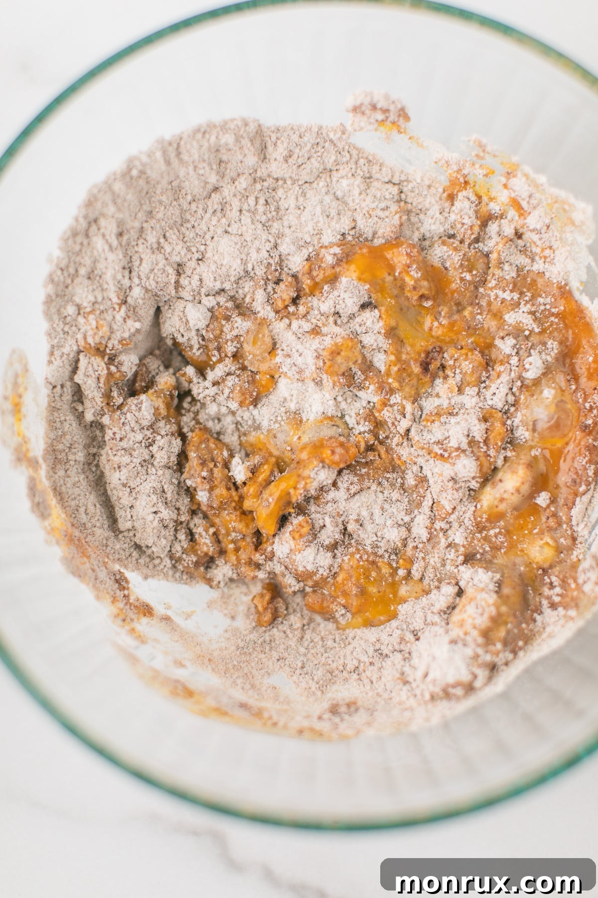 A vibrant image of the wet and dry ingredients for the Instant Pot Pumpkin Spice Cake beautifully blended together in a mixing bowl, creating a rich, smooth batter.