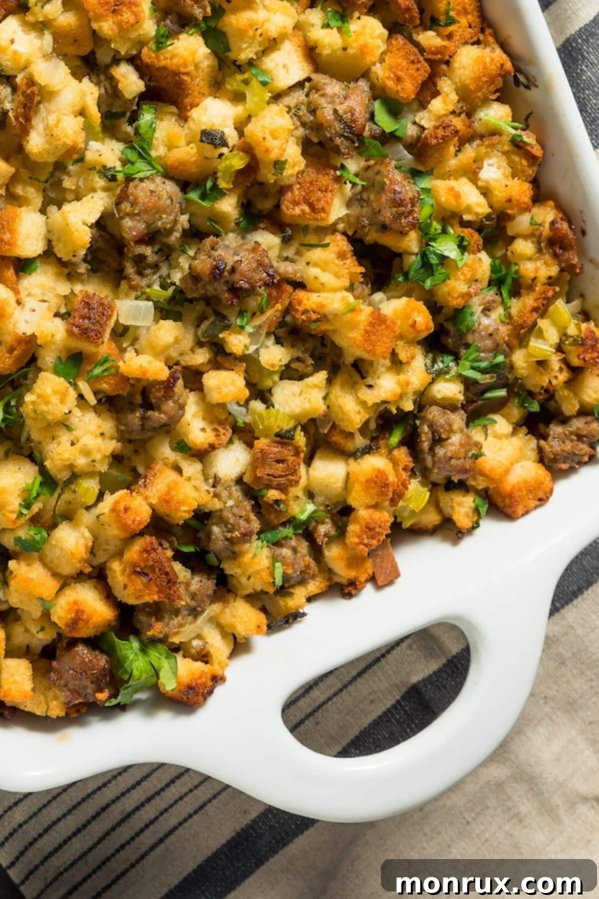 Hearty sausage stuffing served beautifully in a white casserole dish, garnished with fresh herbs.