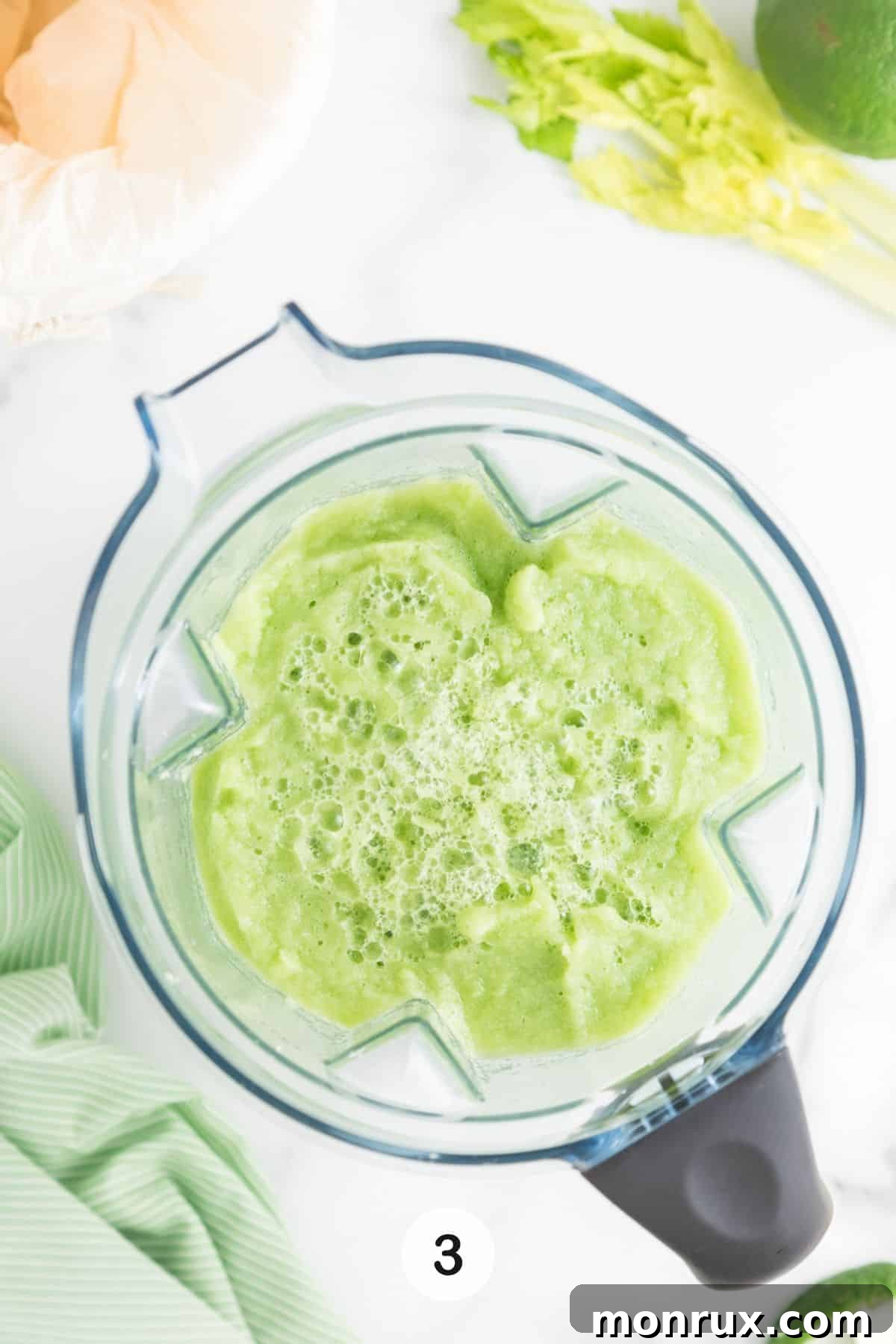 Blended celery and water mixture swirling inside a high-speed blender.