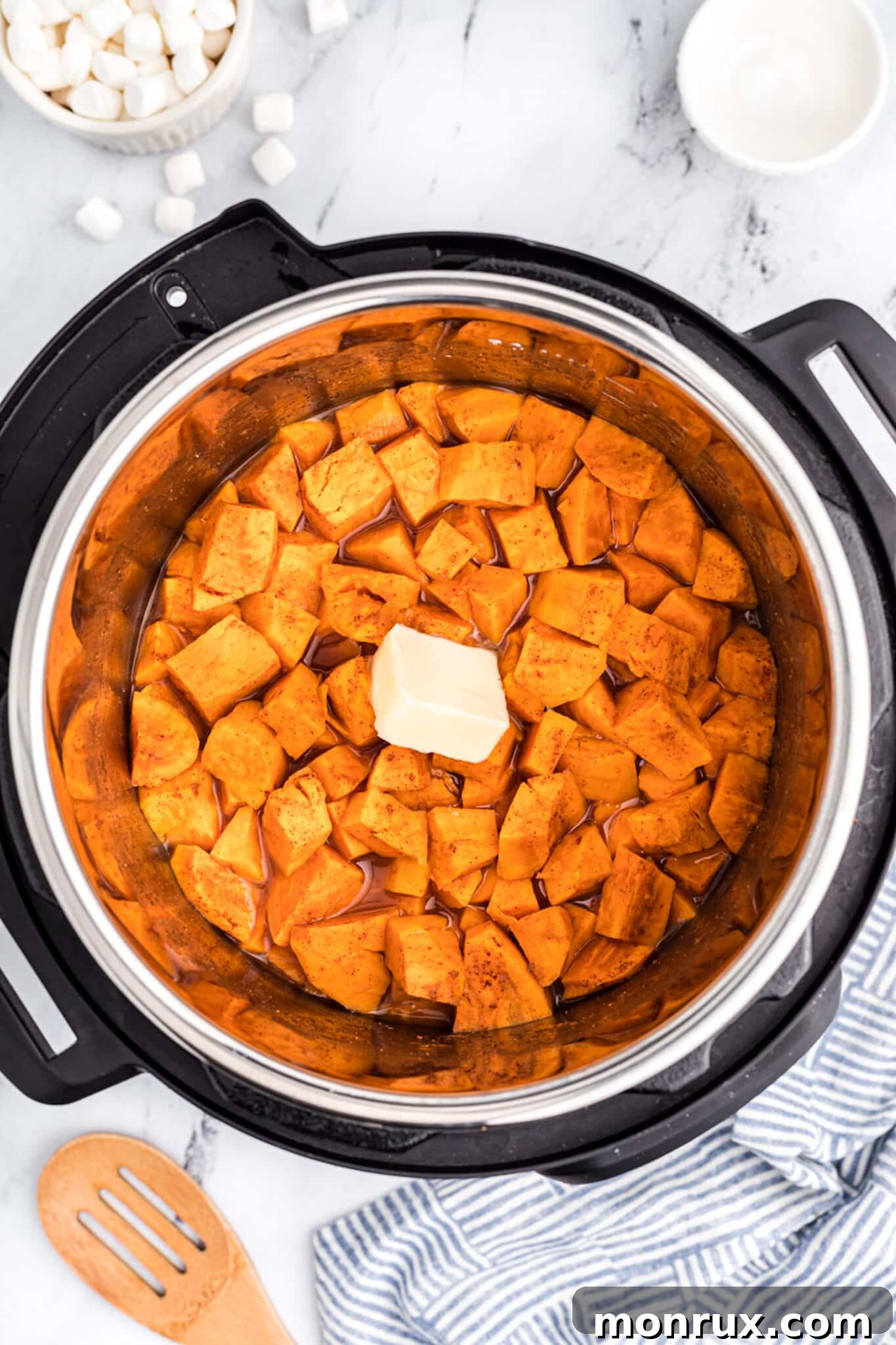 Cooked yams inside the Instant Pot with a pat of butter melting on top.