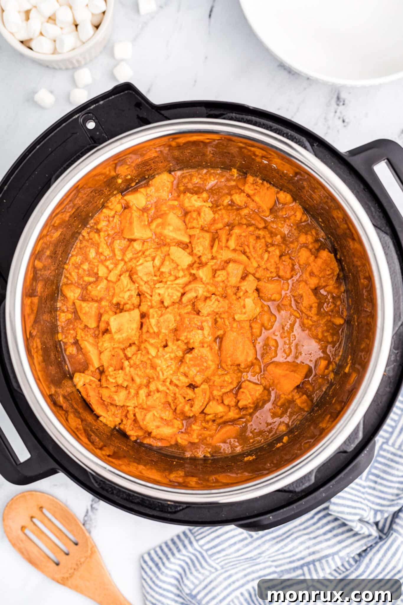 Cooked and lightly mashed yams in the Instant Pot, stirred with butter, ready for serving.