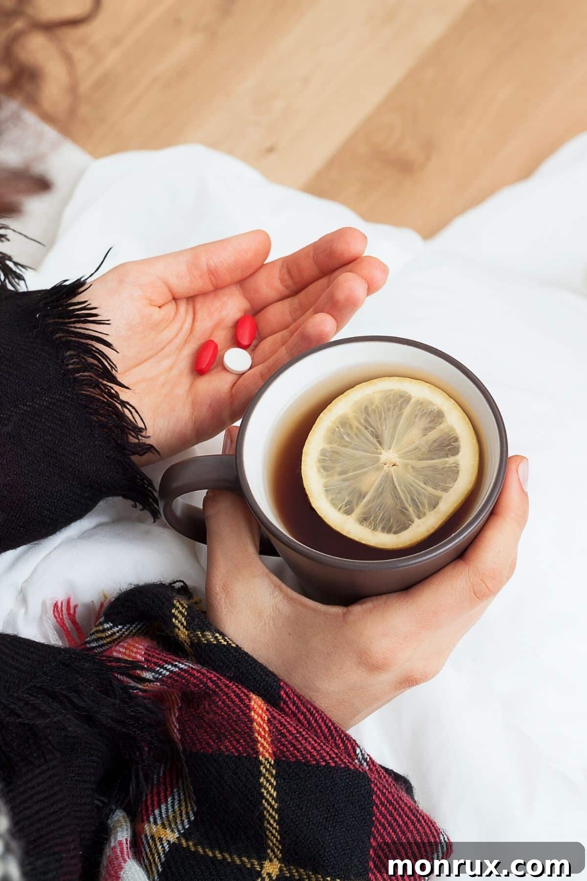 Woman holding a cup of herbal tea and immune-boosting supplements, suggesting comfort and natural remedies during illness.