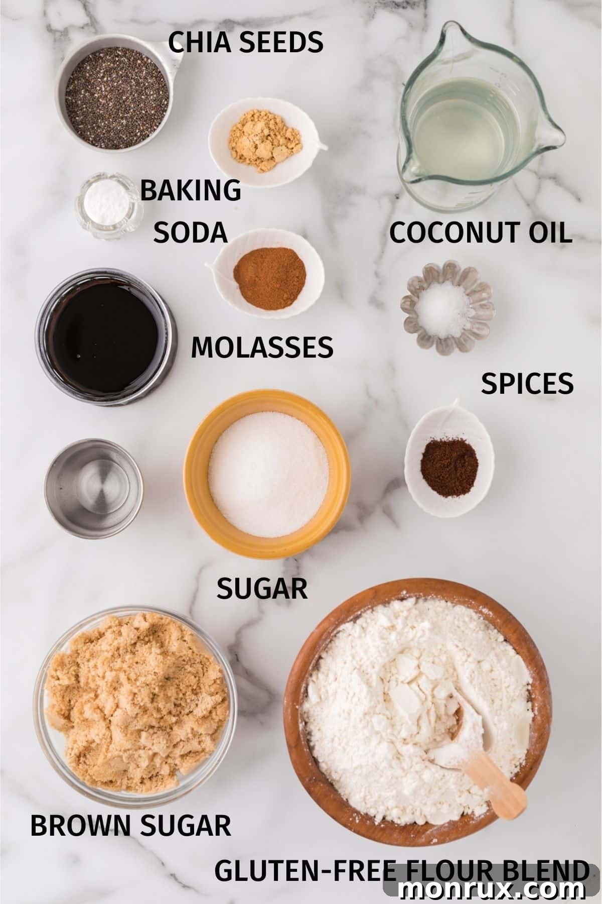 A vibrant display of fresh and dry ingredients for vegan gingersnap cookies, including chia seeds, flour, brown sugar, molasses, and an array of warm spices, laid out on a rustic surface.