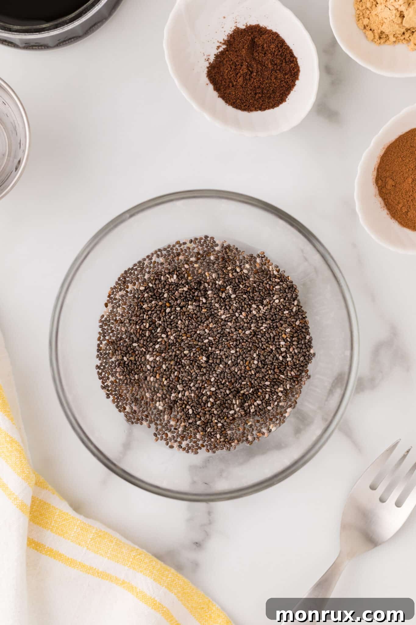 Close-up of a small bowl containing chia seeds and water, beginning to form a gelatinous chia egg, a key vegan binder for cookies.